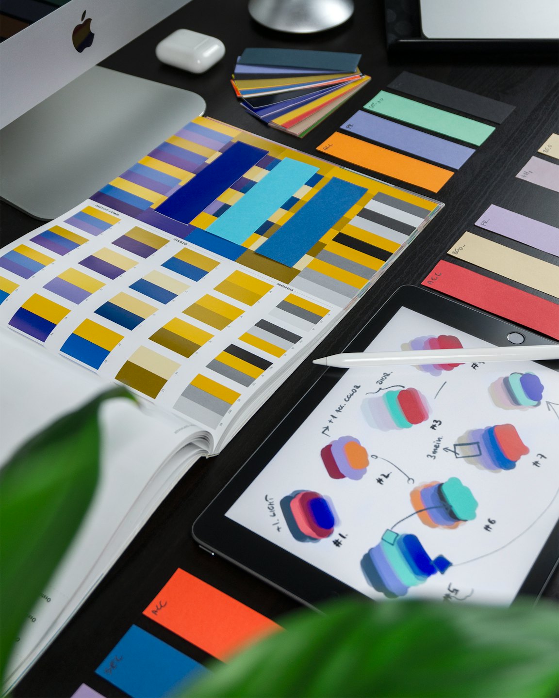Schreibtisch eines Designers mit Farbfeldern, iPad und Apple Pencil.